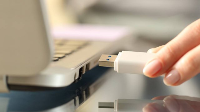 mani di donna inseriscono pen drive in porta usb del pc