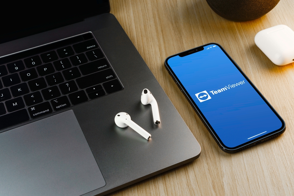 Laptop, airpods e smartphone con app TeamViewer Laptop, airpods e smartphone con app TeamViewer