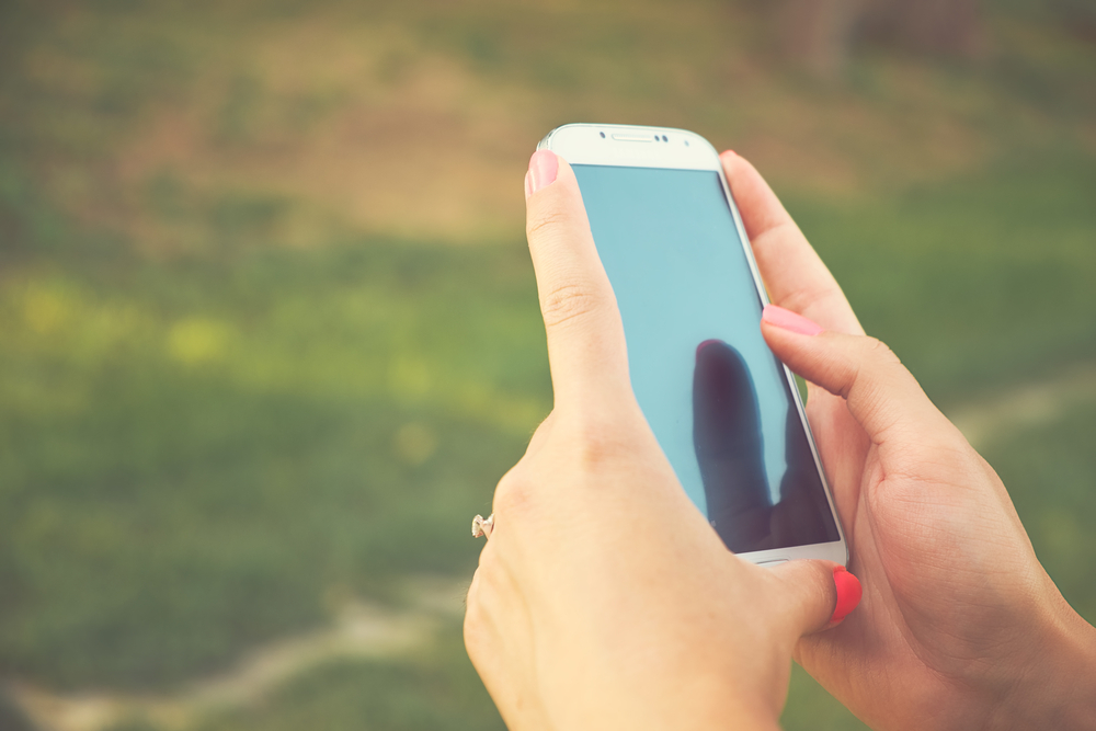 Mani di donna con cellulare Mani di donna con cellulare