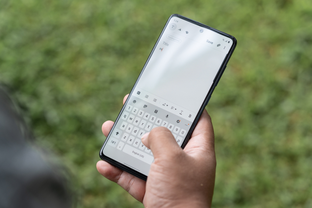 Mani maschili usano tastiera su smartphone Mani maschili usano tastiera su smartphone