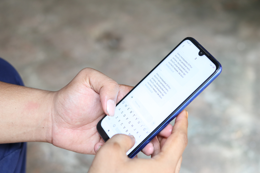 Ragazzo scrive sms su smartphone