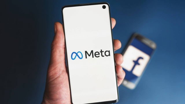 Smartphone con scritta Meta davanti a smartphone con scritta Facebook