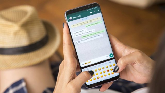 mani femminili con cellulare scrivono in chat whatsapp