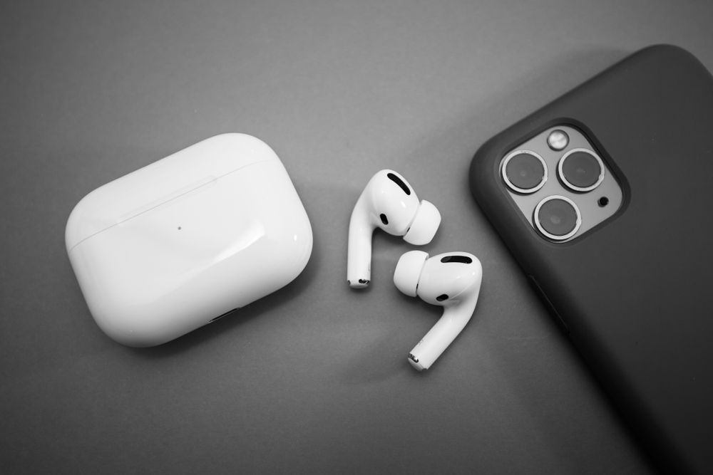 Airpods, custodia e iphone su scrivania Airpods, custodia e iphone su scrivania