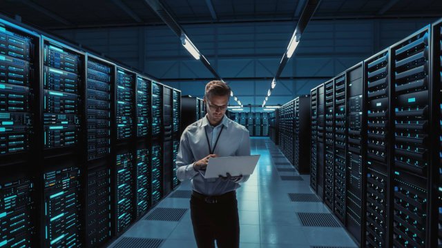 professionista al pc all'interno di un data center