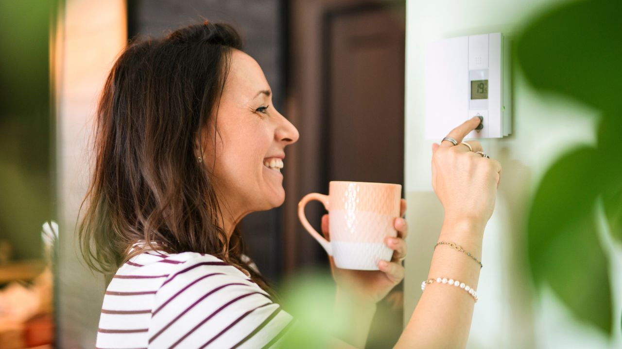 Donna imposta il termostato Donna imposta il termostato