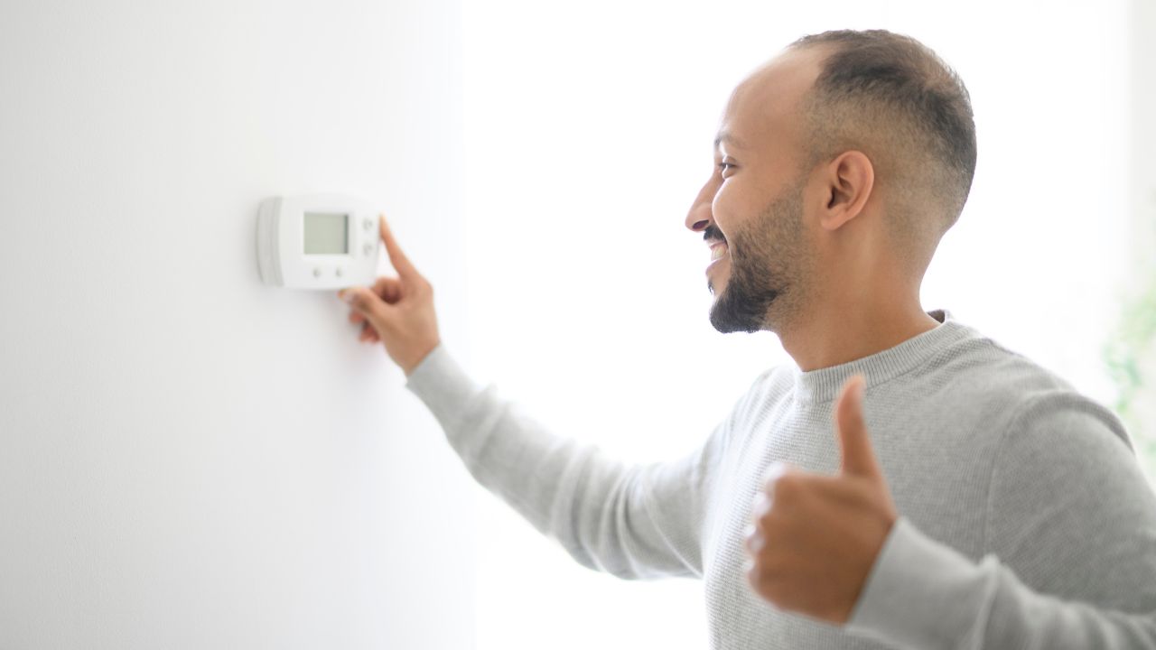 Uomo imposta il termostato Uomo imposta il termostato