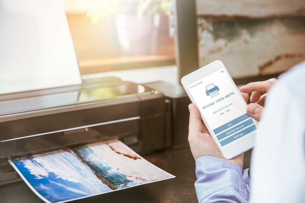 Uomo configura connessione smartphone con una stampante wireless