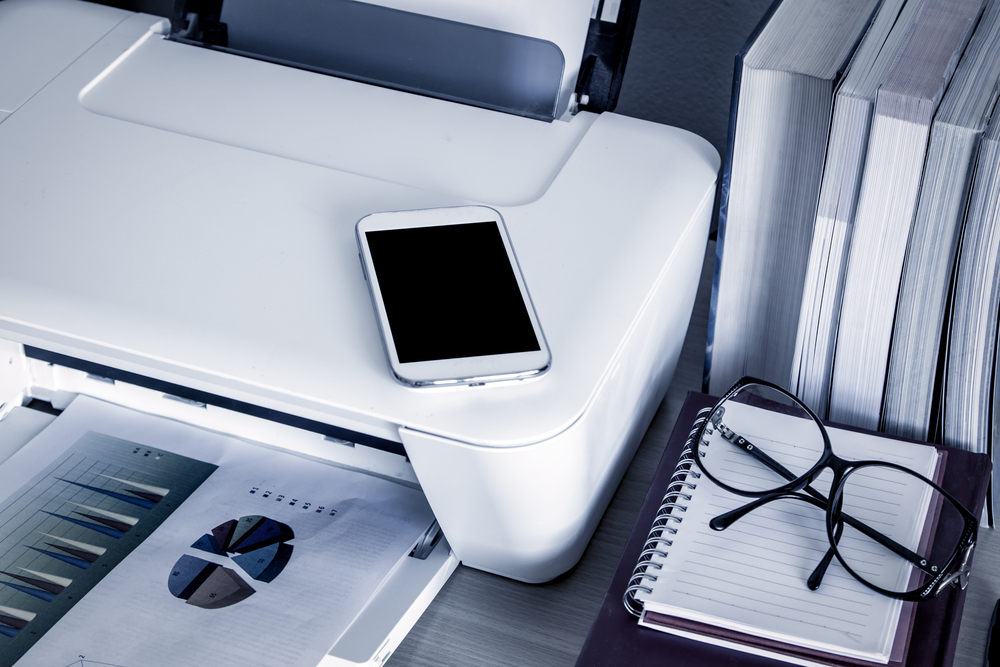 Smartphone poggiato su stampante Smartphone poggiato su stampante