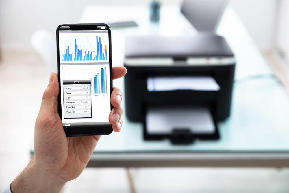 Serie di grafici su smartphone con stampante sullo sfondo