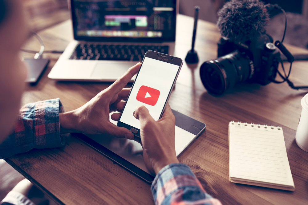 Ragazzo con smartphone avvia app YouTube Ragazzo con smartphone avvia app YouTube