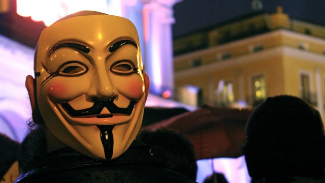 Un manifestante indossa la maschera di Guy Fawkes, simbolo del movimento Anonymous