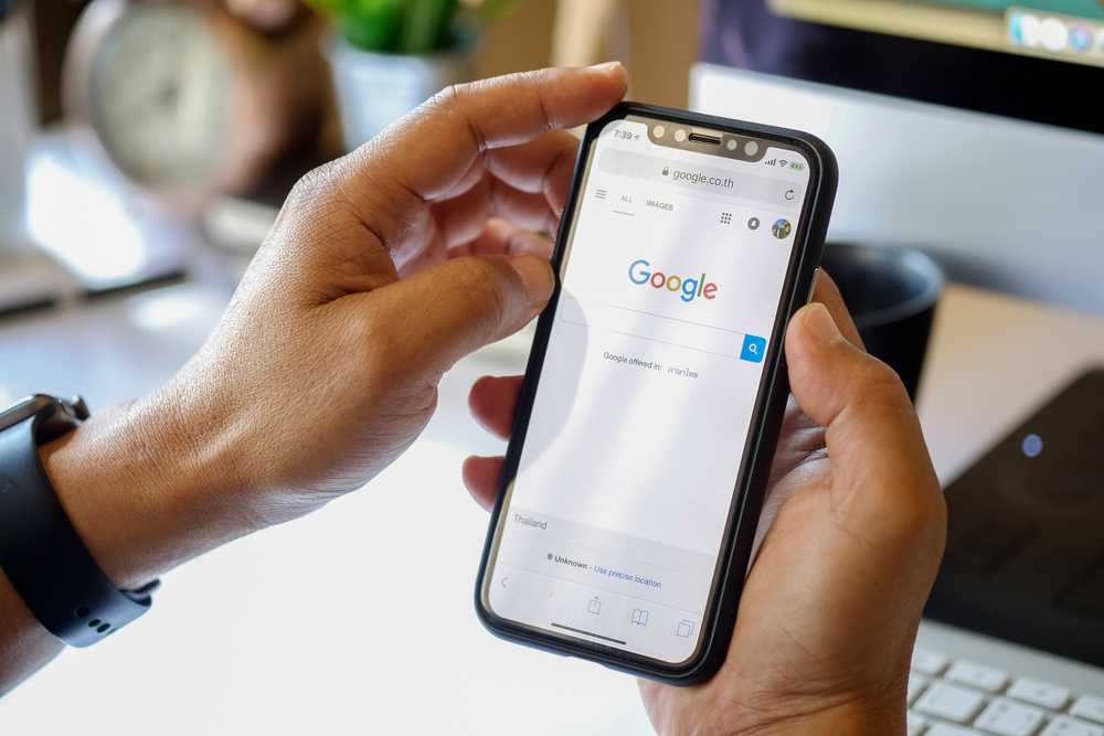 Ragazzo con smartphone su schermata Google Ragazzo con smartphone su schermata Google