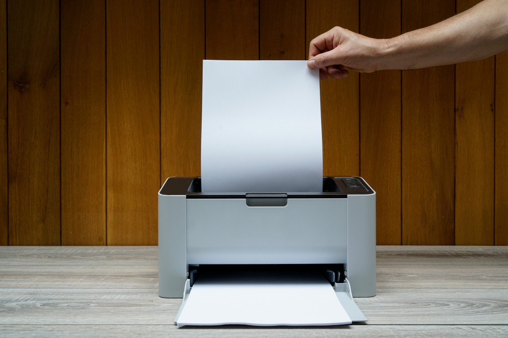 Mano maschile ritira foglio dalla stampante Mano maschile ritira foglio dalla stampante