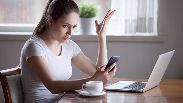 Ragazza disperata con telefono tra le mani