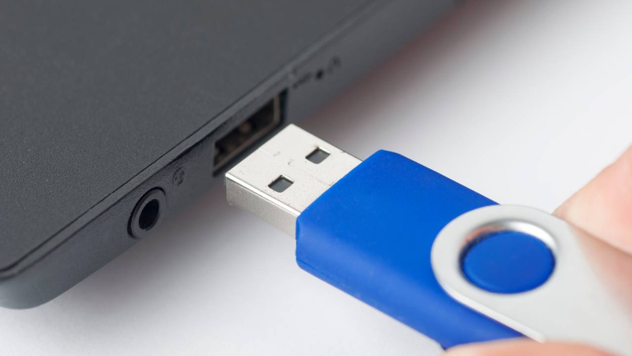 mano che inserisce una pen drive in porta usb del pc