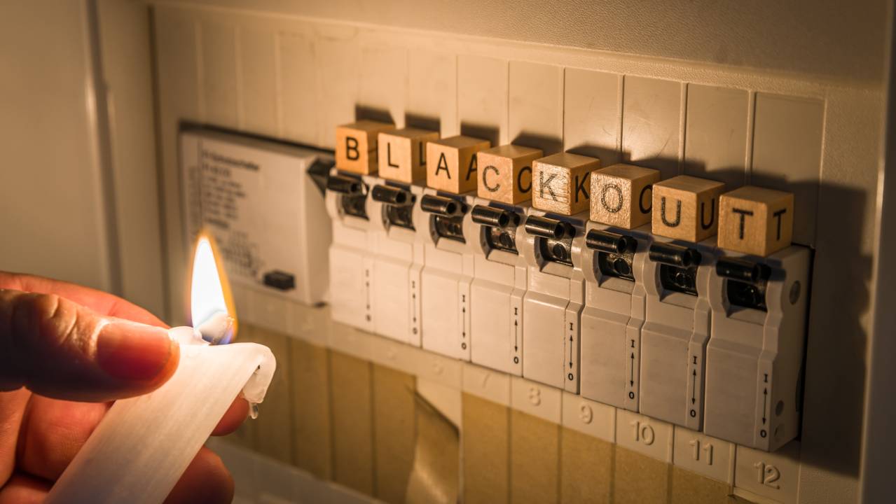generatore elettrico in blackout illuminato con una candela accesa