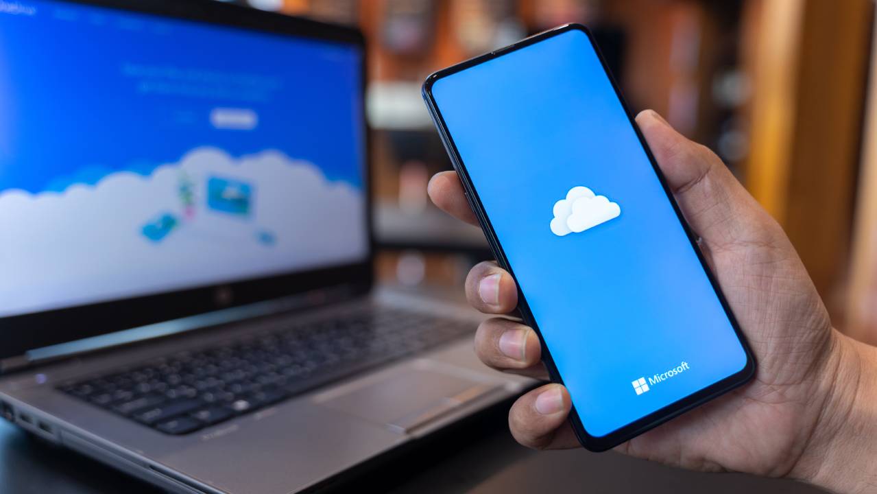 icona Microsoft OneDrive su smartphone e pc sullo sfondo
