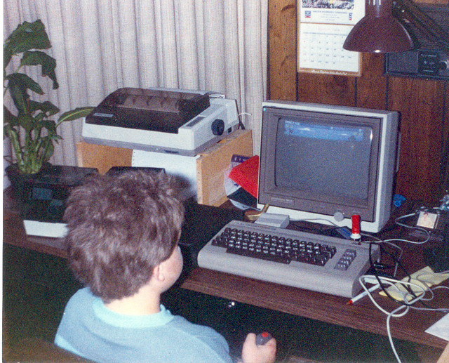 Un bambino gioca con un Commodore 64 in una foto dell'epoca