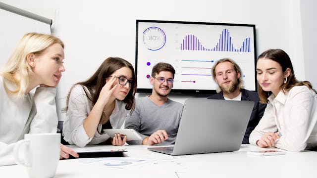 Man and Woman Sitting at Table With Macbook