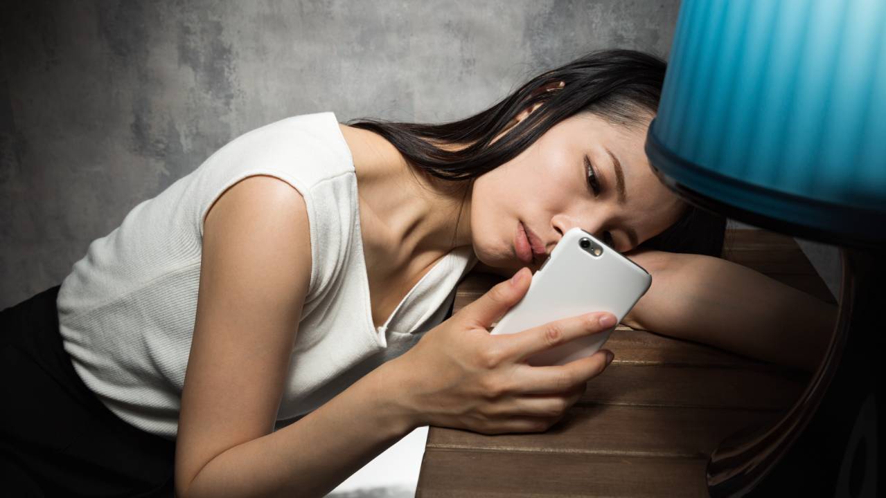 ragazza triste e preoccupata osserva il suo smartphone