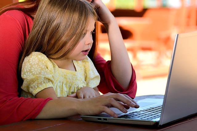 Adulto utilizza il computer con un bambino