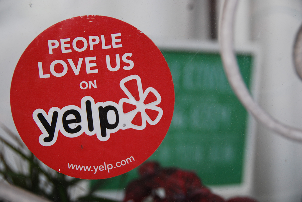 Sticker di Yelp sulla porta di un locale con rating alto
