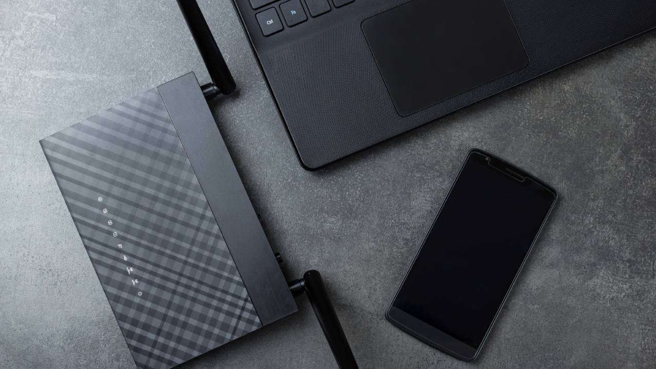 router wifi con laptop e smartphone su scrivania