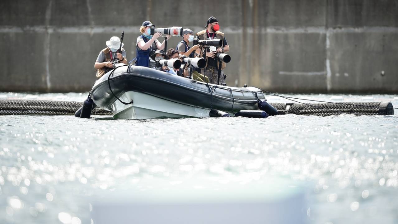 fotoreporter su una barca mentre scattano foto