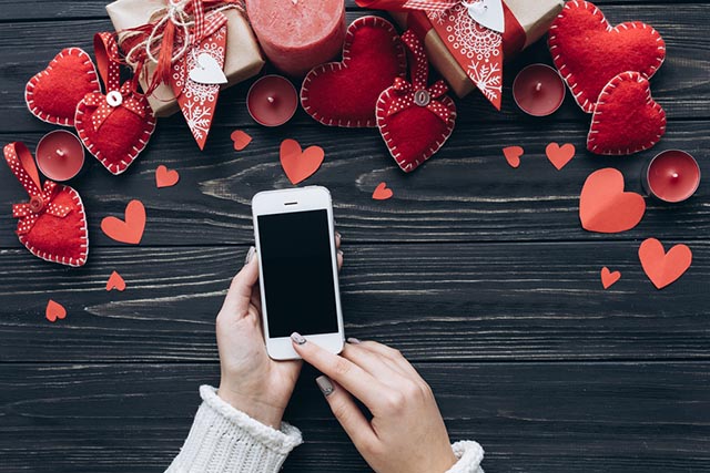 Smartphone contornato di cuoricini per scrivere frasi di san Valentino