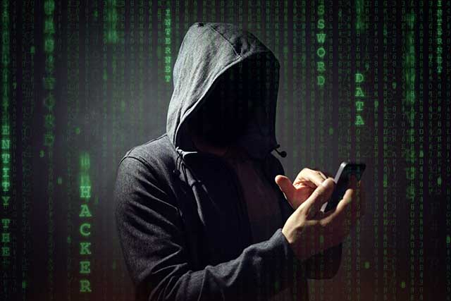 Cybercriminale con smartphone in mano